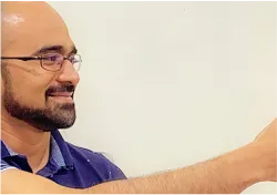 A man in a blue shirt is pointing at something